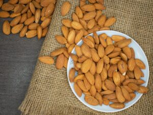 pexels-photo-3997459-3997459-1 Top view of almonds in a white bowl on a burlap surface, highlighting healthy snacking.